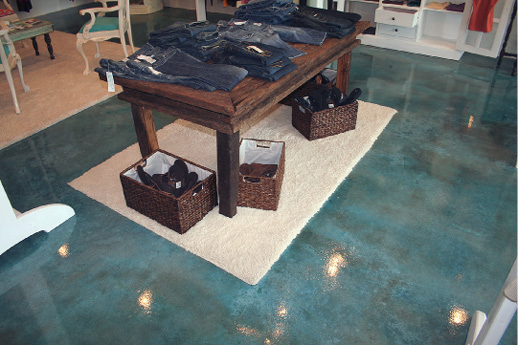 Clothing table in a retail store on top of a blue stained concrete floor.