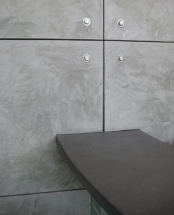 Vertical wall panels made of concrete give an ultra modern feel to this office space that is sporting a dark gray concrete desk.