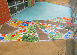 Hand painted flora and fauna native to Texas as well as put down quotes that reflect their experiences with the youth arts organization all on a concrete overlay by Butterfield Color in Texas.