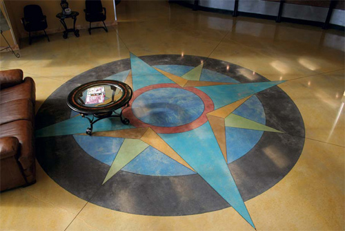A colorful compass that has been stained into a concrete floor.