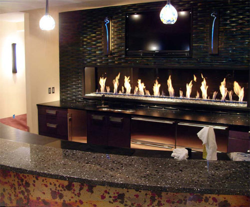 A concrete countertop bar top in front of a fire feature backdrop