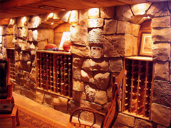 Concrete wine cellar that is lit and staged to have a very cozy look.