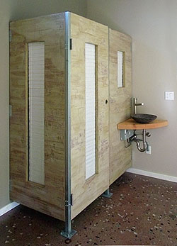 The toilet-stall walls of this bathroom project were created with multiple passes of integrally colored Sgraffino trowelable overlay over crackle medium (to produce craze cracking), all on top of wooden doors. They were sanded with soft diamond pads to produce a layered distressed finish. The sink is the same overlay applied through a ketchup squeeze bottle over a bamboo bowl and sanded with soft diamond pads for a cleanable finish. Photo courtesy of The Concretist.