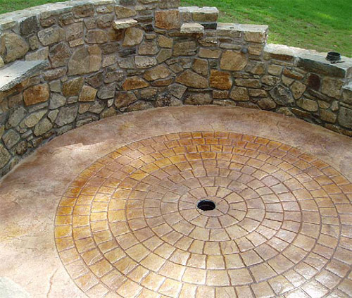 Stamped concrete circular brick pattern with a drain in the center.
