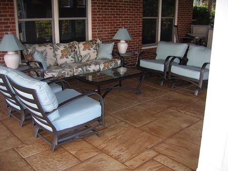 Stamped concrete patio with blue cushioned lounge chairs.