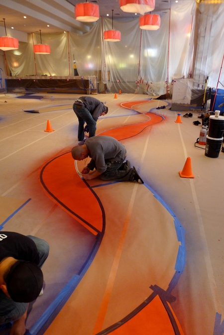 Workers placing color on a concrete floor.