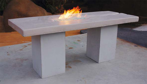 Concrete table with an integrated fire feature stands tall on large square concrete legs.
