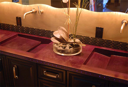 Deep eggplant colored concrete countertop, square integral sinks, LED lighting on face.