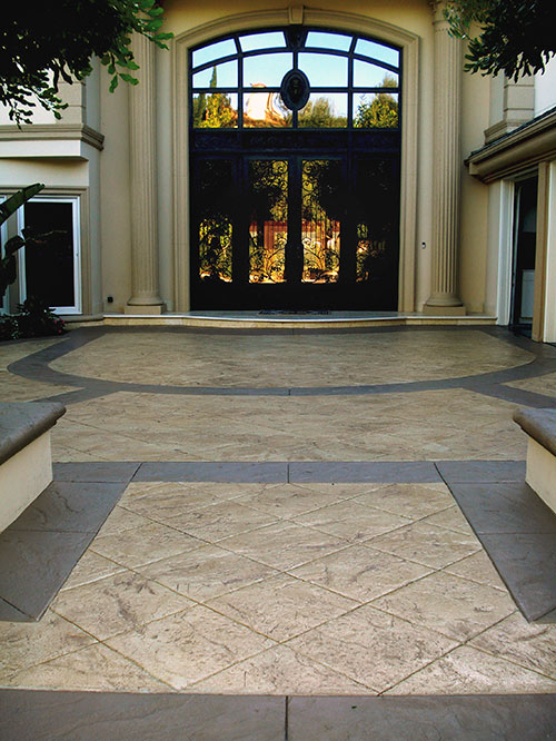 Huge entry near front gate of an indoor garden area with stamped colored concrete