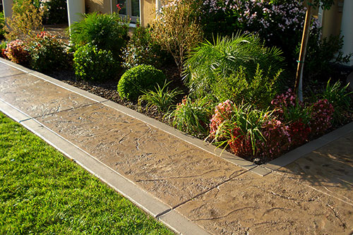 Neighborhood sidewalk featuring textured concrete with a smooth finished border.