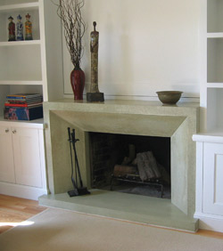 Concrete fireplace precast in a light gray green color has an architectural design element.