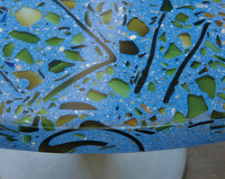 Recycle colored glass impregnated in a blue precast concrete countertop which was then ground to a smooth sheen.