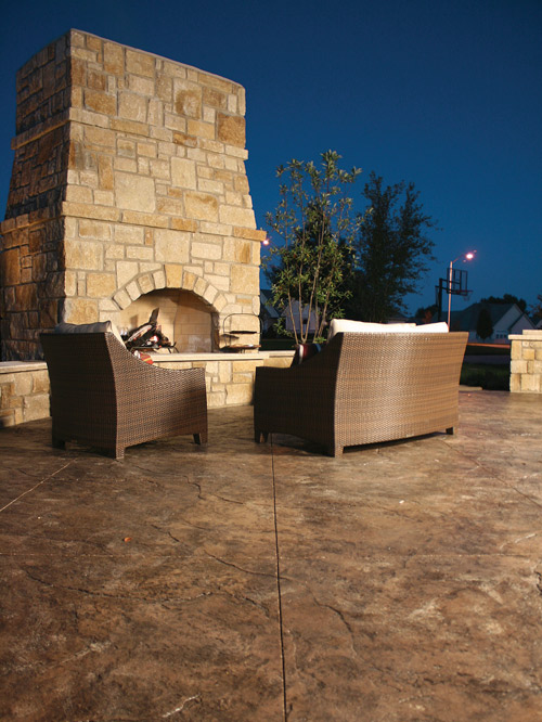 A look at a large concrete fireplace on an outdoor patio.