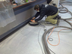 Travis Wilkerson hand-grinds the floor next to a counter at Colonial Harley Davidson, in Prince George, Va.