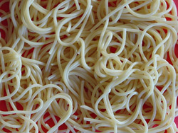 A pile of spaghetti noodles on a red background
