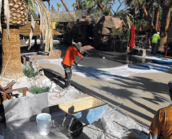 installing backyard concrete in a beachy tropical way.